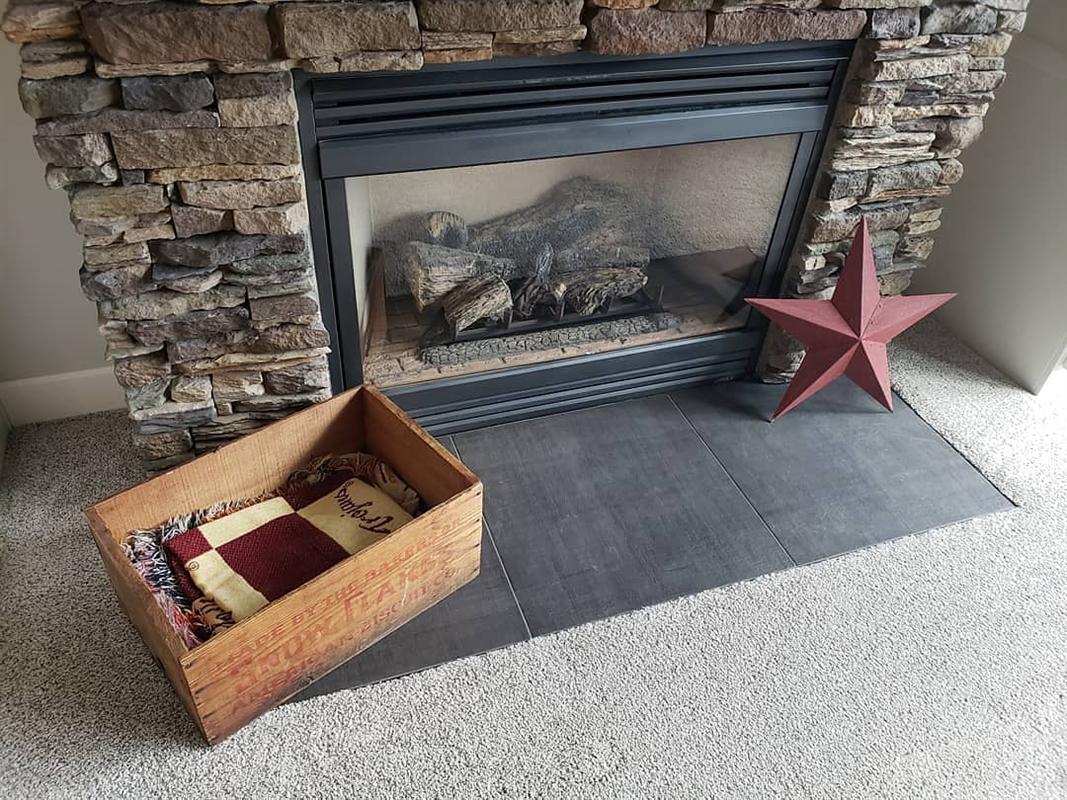 The finished fireplace hearth in large-format slate tile, laid up to the existing stone surround