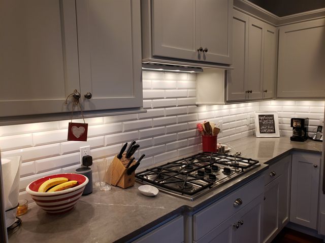 Kitchen with a white subway tile backsplash behind a gas range